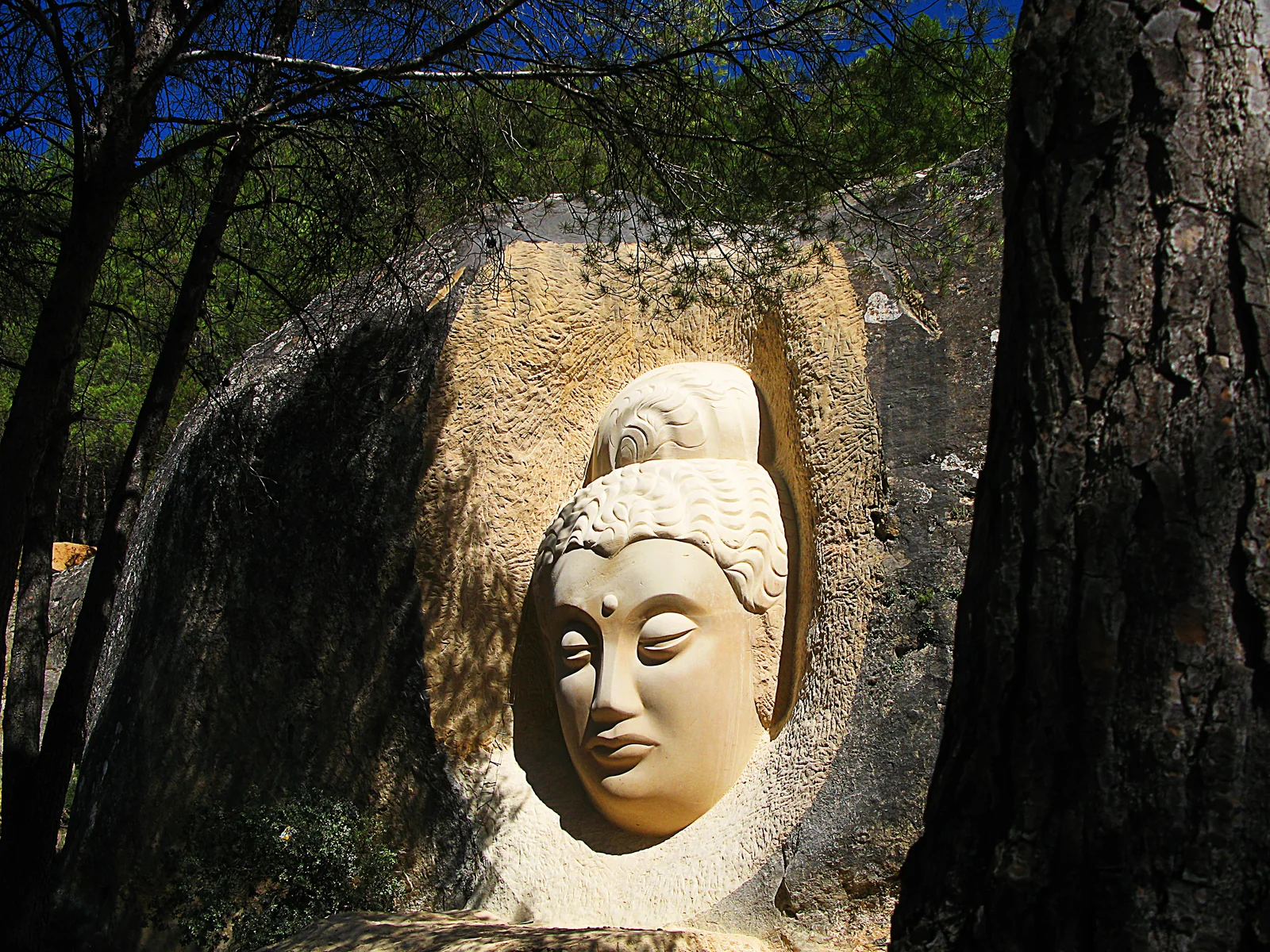 Escultura de Maitreya, una de las figuras del conjunto de la Ruta de las Caras, tallada en el pinar de San Isidro