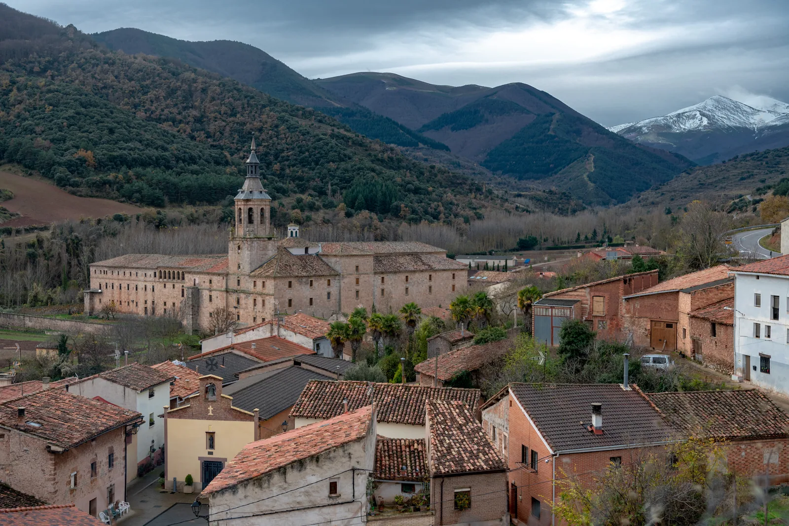 El monasterio de Yuso y el pueblo de San Millán de la Cogolla, con la sierra de la Demanda nevada al fondo