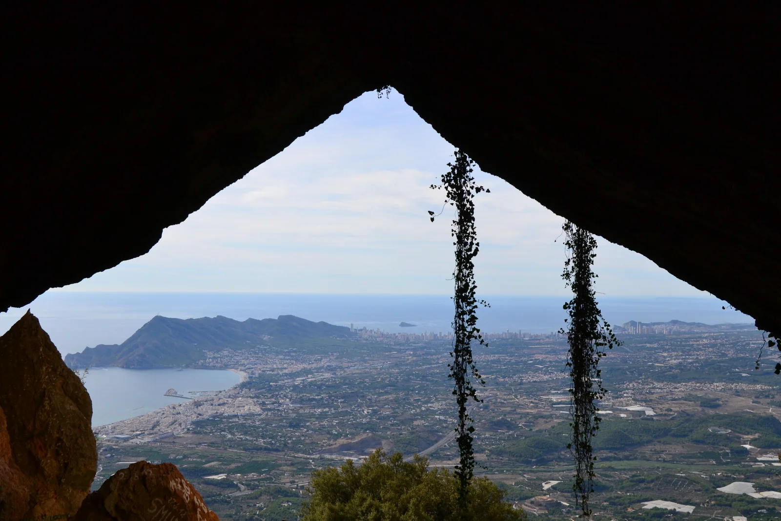 Interior del Forat de Bèrnia, el túnel natural que atraviesa la cresta de la sierra, con la luz del Mediterráneo al fondo