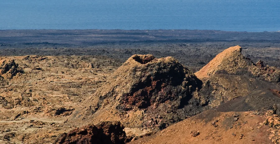 Campo de lavas volcánicas negras del Parque Nacional de Timanfaya con el Atlántico al fondo, Lanzarote