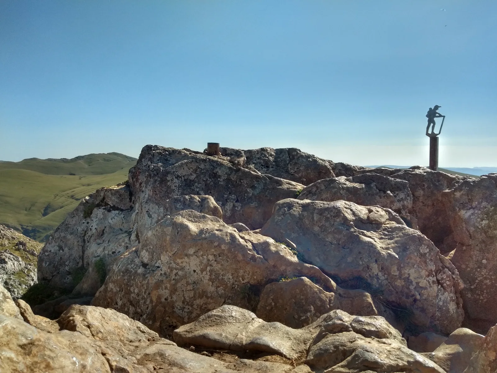 La cumbre del Txindoki con su placa, sobre los pastos de la Sierra de Aralar
